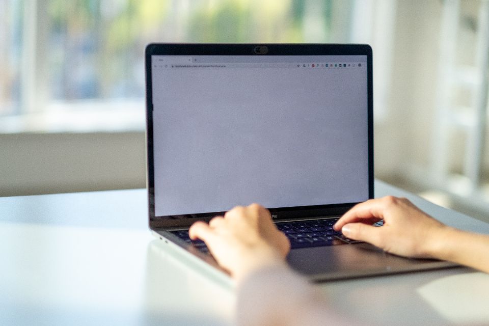 Händer som skriver på en bärbar dator vid ett skrivbord